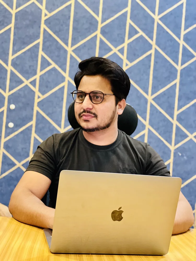 Shanawar focused at his desk with a MacBook