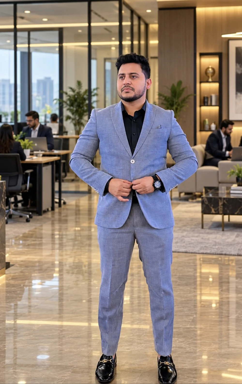 Shanawar in a grey suit standing in a modern corporate office